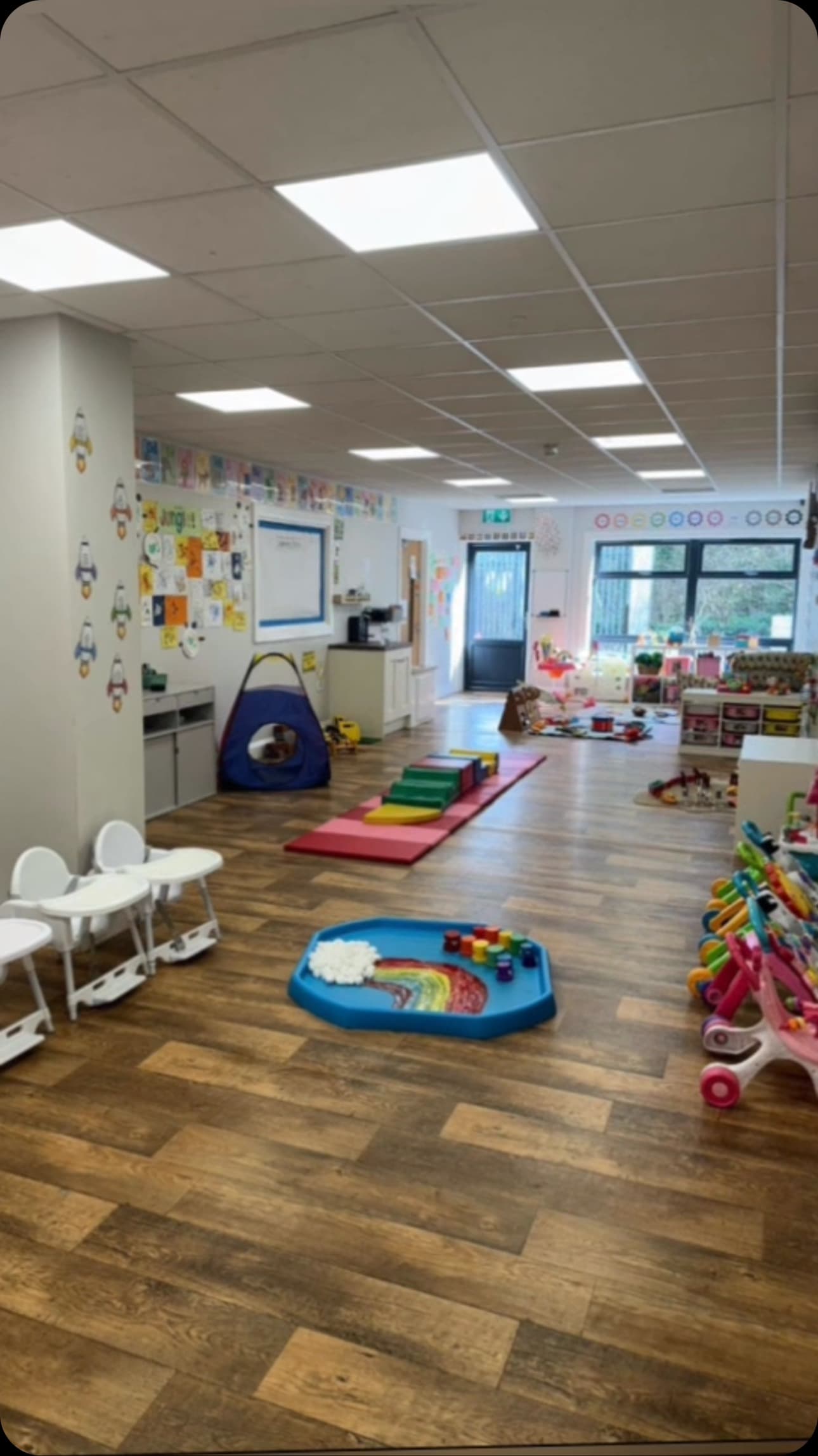 A bright indoor playroom at Happy Kids, with toys, play mats and space to explore