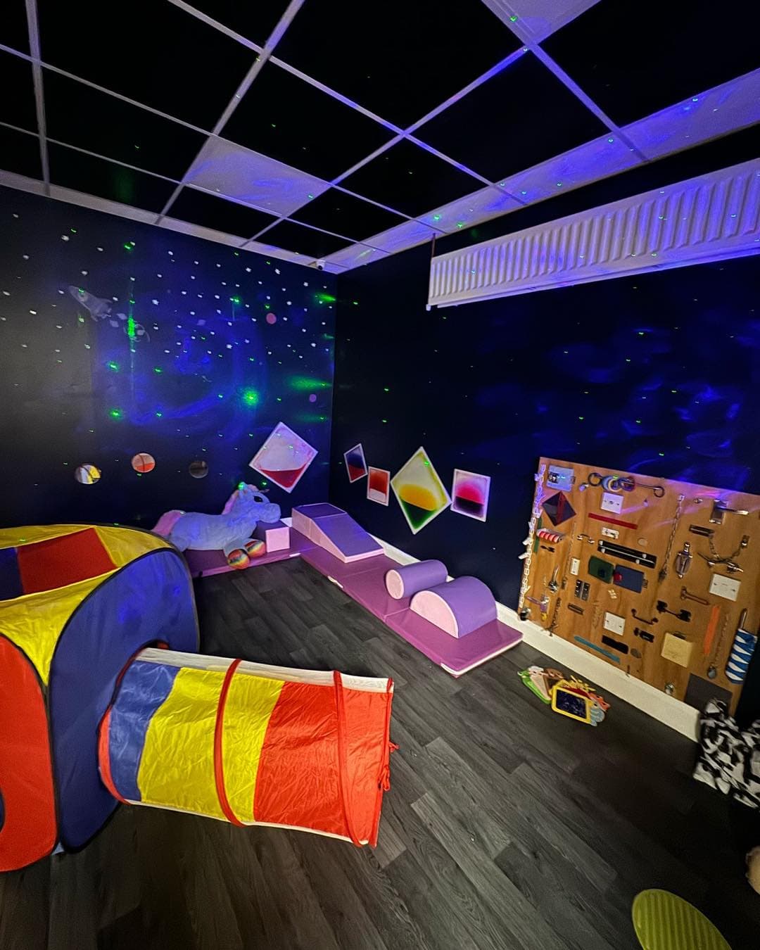 Happy Kids sensory room with soft play equipment and glowing lights